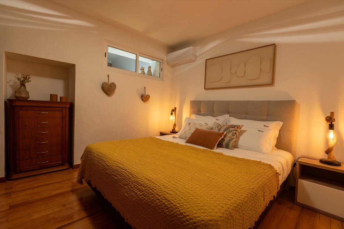 Quarto com cama king size e almofadas em tons de terra